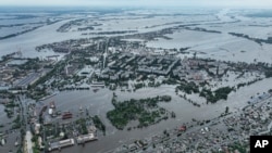 Houses are seen underwater and polluted by oil in a flooded neighbourhood in Kherson, Ukraine, Saturday, June 10, 2023. (AP Photo)