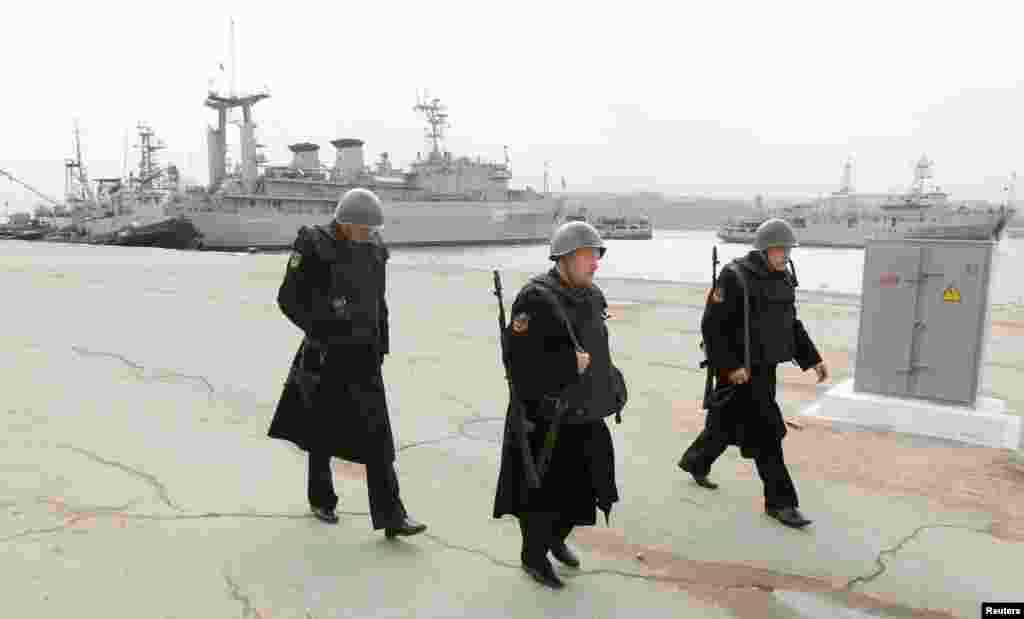 Pelaut Rusia bersenjata berjalan dekat kapal Ukraina Slavutich di Sevastopol, 20 Maret 2014.