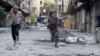 FILE - Mohammad (R), a 13 year-old fighter from the Free Syrian Army, aims his weapon as he runs from snipers loyal to the Syrian regime in Aleppo's Bustan al-Basha district October 29, 2013.