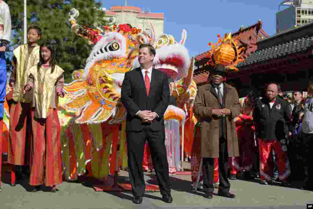 旧金山市市长马克·法雷尔2018年2月16日在旧金山举行的农历新年庆祝活动中聆听。 右边是前市长威利·布朗。鸡年结束,狗年开始。