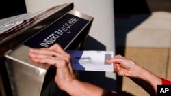 ARCHIVO - Una persona deja una boleta por correo en una urna electoral en Willow Grove, Pensilvania, EEUU, el 25 de octubre de 2021.