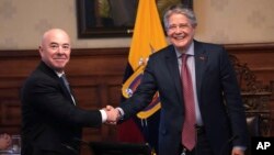 El secretario de Seguridad Nacional de Estados Unidos, Alejandro Mayorkas, y el presidente ecuatoriano Guillermo Lasso se dan la mano mientras posan para una foto en el palacio de gobierno en Quito, Ecuador, el miércoles 7 de diciembre de 2022.