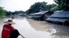 បុរស​ម្នាក់​ចែវ​ទូក​របស់​គាត់​នៅ​ក្បែរ​ផ្ទះ​ដែល​លិច​ទឹក​ នៅ Nyaung Tone ក្នុង​តំបន់​ដី​សណ្ត Irrawaddy ប្រហែល​១០០គ.ម​ភាគ​និរតី​នៃ​ក្រុង​យ៉ាំងហ្គូន ប្រទេស​មីយ៉ាន់ម៉ា កាលពី​ថ្ងៃទី៥ ខែសីហា ឆ្នាំ២០១៥។