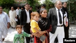 Khalida Bibi (tengah), saudara perempuan Farzana Iqbal, didampingi pengacara saat tiba di pengadilan Lahore untuk sidang para tersangka pembunuhan adiknya, Juni 2014.