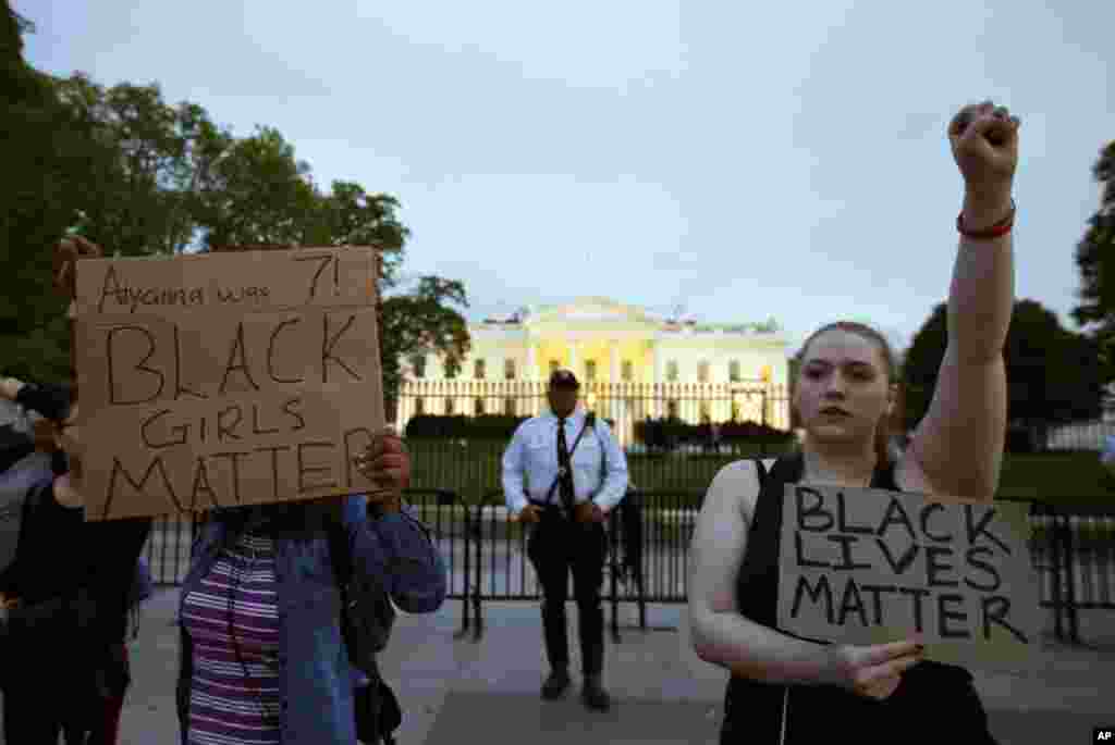 Protestors hold signs in front of the White House during a protest to support the rallies in Baltimore, April 29, 2015.