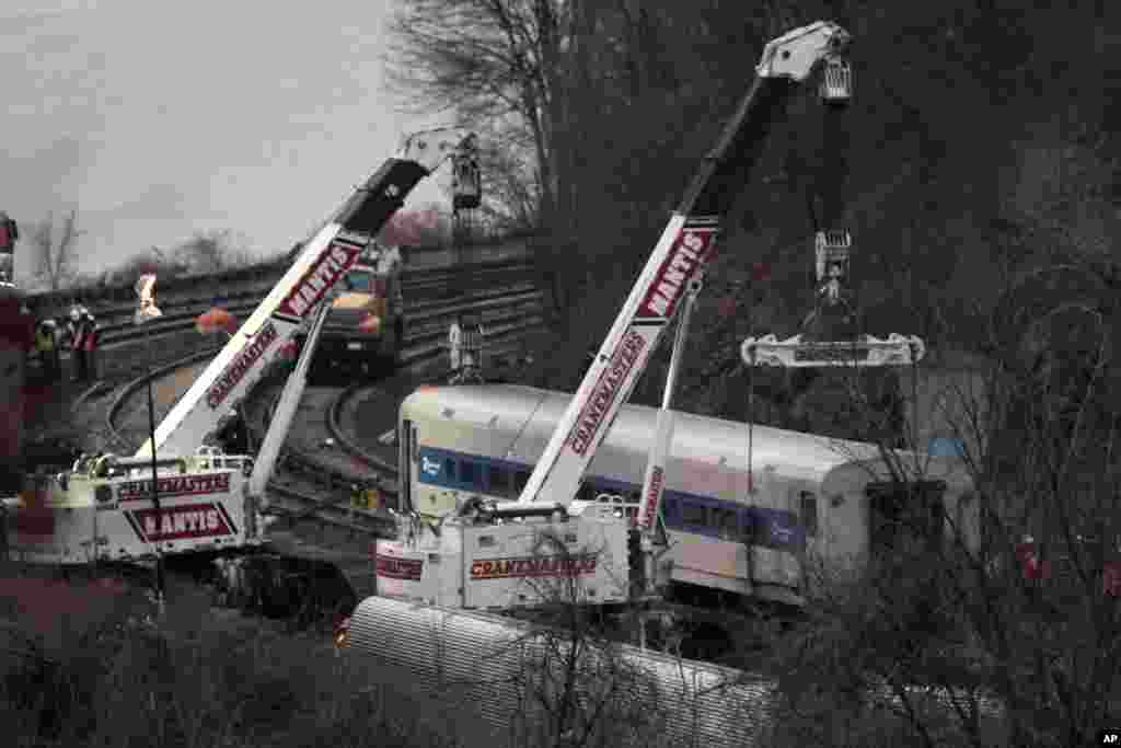 Mesin derek mengangkat gerbong kereta Metro-North yang tergelincir di Bronx, New York, 2 Des., 2013.