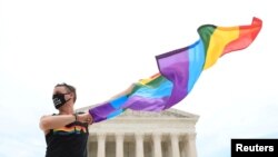 Joseph Fons holding a Pride Flag, stands in front of the U.S. Supreme Court building after the court ruled that a federal law banning workplace discrimination also covers sexual orientation, in Washington, D.C., U.S., June 15, 2020.