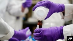 ARCHIVO - Investigador vierte una muestra de agua en un recipiente más pequeño en un experimento sobre el agua potable y los PFAS en un laboratorio de la Agencia de Protección Medioambiental (EPA, por sus siglas en inglés) en Cincinnati, el 16 de febrero de 2023.