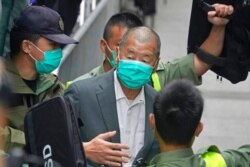 FILE - Democracy advocate Jimmy Lai, center, leaves the Hong Kong's Court of Final Appeal in Hong Kong, Feb. 9, 2021.