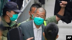 FILE - Democracy advocate Jimmy Lai, center, leaves the Hong Kong's Court of Final Appeal in Hong Kong, Feb. 9, 2021.
