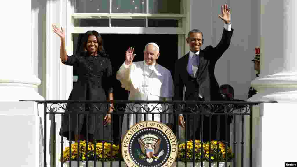 Le pape François, au milieu, le président Barack Obama, à droite, et la première dame américaine, saluent de la main depuis un balcon lors de l'accueil officiel du souverain pontife à la Maison-Blanche, Washington, 23 septembre 2015.