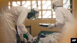 Dr. Kent Brantly (kiri) merawat seorang pasien ebola di Monrovia, Liberia (foto: dok). Dr. Brantly tertular ebola dan harus dirawat di AS. 