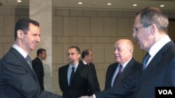 Presiden Suriah Bashar al-Assad menyalami Menlu Rusia Sergei Lavrov (kanan) yang berkunjung ke Damaskus (7/2).