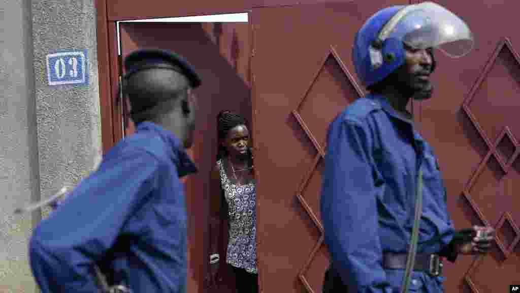 Un habitant du quartier regarde la police anti-émeute qui patrouille à pied dans le quartier de Nyakabiga, Burundi, lundi 4 mai 2015.