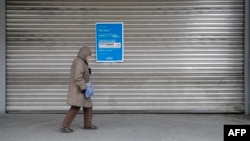 Una mujer pasa por una tienda por departamentos de la cadena minorista alemana Galeria del grupo Galeria Karstadt Kaufhof el 2 de abril de 2020 en Berlín, cerrada como la mayoría de las tiendas en una medida para limitar la propagación del nuevo coronavirus. 