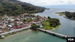 Aliran Sungai yang membela kota Tentena, dengan latar gunung dan danau Poso di kejauhan. (Foto: VOA/Yoanes) 