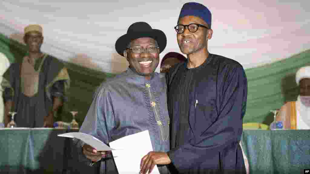 Le président Goodluck Jonathan du Nigeria, à gauche, et le candidat de l'opposition, le gén. Muhammadu Buhari, à droite, se tiennent main dans la main après avoir signé le renouvellement de leur engagement pour des élections pacifiques "libres, justes et crédibles", à Abuja, Nigeria jeudi 26 mars 2015