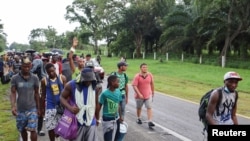 Migrantes y solicitantes de asilo de Centroamérica y el Caribe caminan en una caravana que se dirige a la capital mexicana para solicitar asilo y estatus de refugiado, en una carretera en el estado de Chiapas, México, el 29 de agosto de 2021.