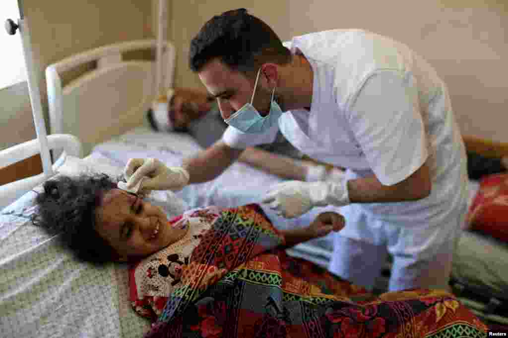 La niña palestina Suzy Eshkuntana, de 6 años, es tratada por un médico en un hospital después de ser sacada de los escombros de un edificio en medio de ataques aéreos israelíes, en la ciudad de Gaza.