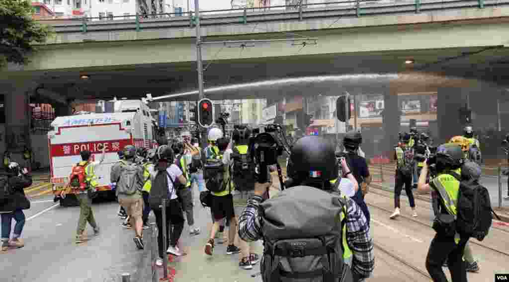 香港警方5月24日出動水炮車,多次在灣仔鵝頸橋噴射胡椒水驅散集結的人群。(美國之音湯惠芸拍攝)