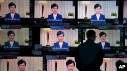 A man watches the television message that Hong Kong Chief Executive Carrie Lam makes an announcement on the extradition bill, at a home electronics retailer in Hong Kong, on Wednesday, Sept. 4, 2019. Chief Executive Lam has announced the government…