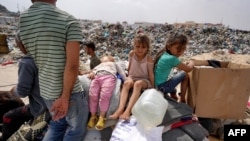 Anak-anak Palestina duduk bersama barang bawaan keluarga setibanya di kamp Khan Yunis di Rafah, Jalur Gaza, menyusul serangan baru oleh Israel, 28 Mei 2024. (Foto: Bashar Taleb/AFP)