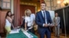 French President Emmanuel Macron and his wife Brigitte Macron pick up ballots before voting in the first round of the two-stage legislative elections in Le Touquet, northern France, June 11, 2017.
