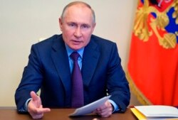 Russian President Vladimir Putin gestures during a meeting via video conference at the Novo-Ogaryovo residence outside Moscow, Russia, April 15, 2021.