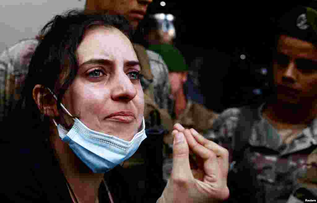A woman reacts as members of security forces attempt to evict displaced people from an old hotel, amid ongoing hostilities between Hezbollah and Israeli forces, in the Hamra neighborhood of Beirut, Lebanon, Oct. 21, 2024. 