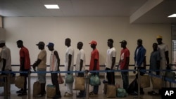 Los sobrevivientes de la piragua senegalesa que fue encontrada a la deriva hacen fila en el aeropuerto antes de abordar un vuelo para ser repatriados, en la isla de Sal, Cabo Verde, el lunes 21 de agosto de 2023.