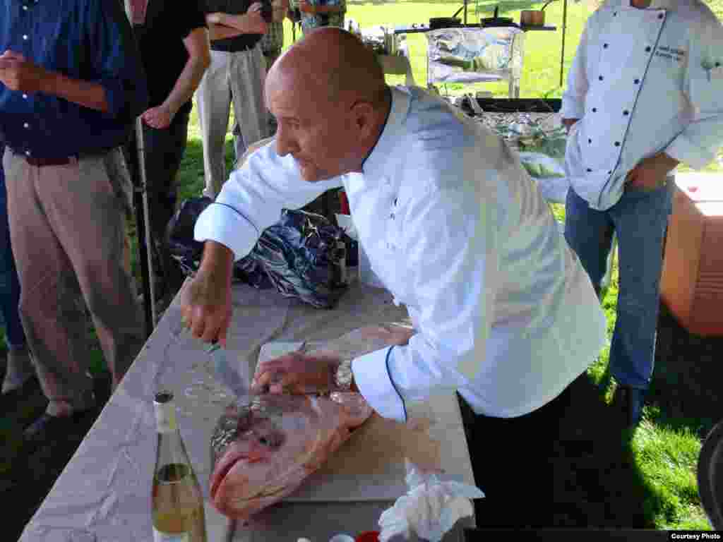 Chef Parola fillets a 13-kilo Asian carp, which he had flown in from Louisiana. (Tom Banse)