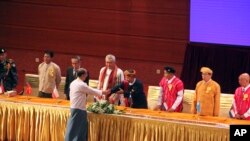 Presiden Myanmar Thein Sein berjabat tangan dengan pemimpin organisasi etnis dalam penandatangan perjanjian perdamaian di Myanmar International Convention Center, Kamis, 15 Oktober 2015 di Naypyitaw, Myanmar (Foto: AP Photo/Aung Shine Oo).