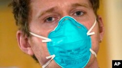 Medicinski tehničar Skot Mekgison nosi masku N95 dok napušta sobu s pacijentima u odeljenju za intenzivnu negu u medicinskom centru Harborvju, u Sijetlu, 14. januara 2022.