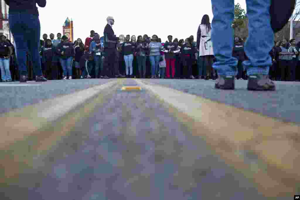 Warga berbaris sambil berpegangan tangan menuju Jembatan Edmund Pettus untuk menghormati Martin Luther King, Jr., di Selma, Alabama (18/1). (AP/Brynn Anderson)