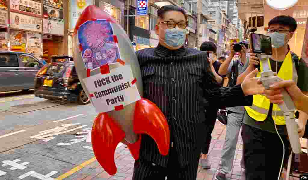 有香港市民10月1日扮成北韓領導人金正恩在銅鑼灣上街,他手持貼上中共總書記習近平病毒頭像的吹氣飛彈,諷刺香港目前的局勢會引發第三次世界大戰。(美國之音湯惠芸)