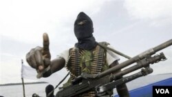 Seorang militan menggunakan penutup wajah hitam dan mengusung senapan Kalashnikov, berpatroli di kawasan Delta Niger (foto: dok).