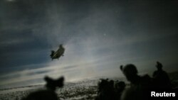 FILE PHOTO: A Chinook helicopter lands to pick up U.S. soldiers of the 101st Airborne Division following a night raid in Yahya Khel, Paktika province, Afghanistan, Feb. 21, 2011.