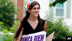 អ្នកស្រី Danica Roem កាន់​ស្លាក​យុទ្ធនាការ នៅ​ពេល​លោកស្រី​ព្យាយាម​ស្វែងរក​ការ​គាំទ្រ​នៅ​ក្នុង​ក្រុង Manassas កាលពី​ថ្ងៃទី២១ ខែមិថុនា ឆ្នាំ២០១៧។