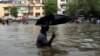A man wades through a waterlogged street following heavy rains in Mumbai, India, Aug. 29, 2017.