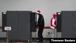 ARCHIVO - Electores en Atlanta, Georgia, votan en las elecciones de segunda vuelta para el Senado de Estados Unidos.