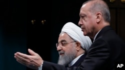 FILE - Turkey Iran SyriaTurkey's President Recep Tayyip Erdogan, right, gestures to Iran's President Hassan Rouhani, as they arrive for a news conference following their meeting at the Presidential Palace in Ankara, Dec. 20, 2018.