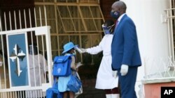 Seorang siswa diperiksa suhu tubuhnya, di pintu masuk sekolah swasta di Harare, Zimbabwe, 14 September 2020. (Foto: AP)