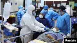 Staf medis dan perawat mengenakan pakaian pelindung, saat membantu memindahkan pasien yang terjangkit Covid-19 ke Rumah Sakit Masih Daneshvari, di Teheran, Iran, 30 Maret 2020. (Foto: dok).