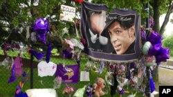 FILE - Items left by fans at a memorial for musician Prince hang from a fence outside Paisley Park, May 11, 2016, in Chanhassen, Minnesota.