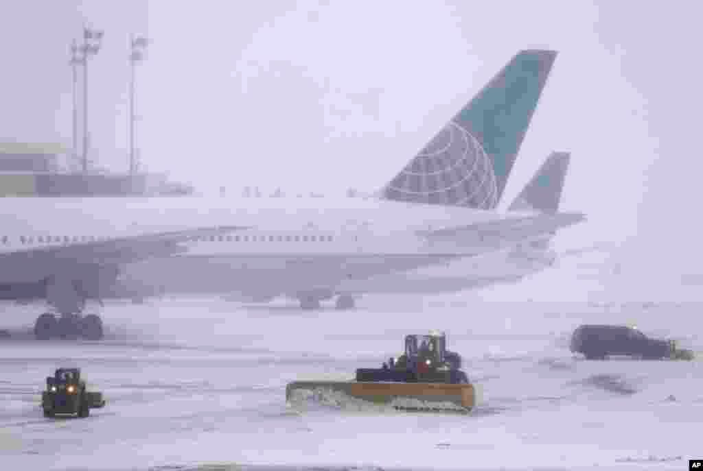 Des pelleteuses nettoient la piste de l'aéroport international de Newark Liberty à Newark, New Jersey, 14 mars 2017.