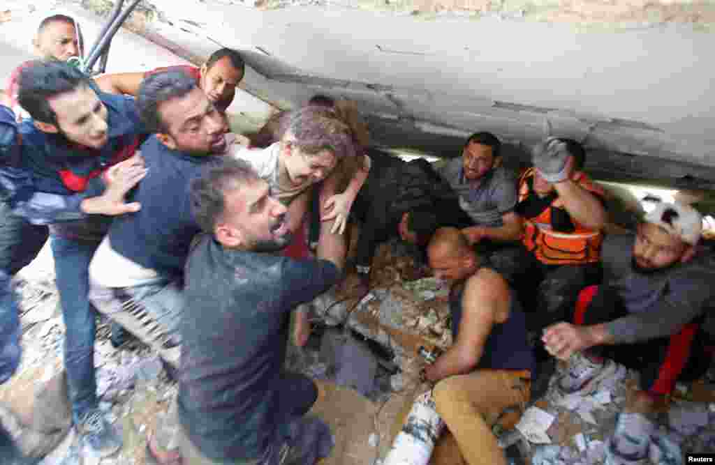Los equipos de rescate llevan a una niña mientras buscan víctimas entre los escombros en el lugar de los ataques aéreos israelíes, en la ciudad de Gaza.