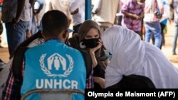 Akris Angelina Jolie, utusan khusus badan PBB untuk urusan pengungsi (UNHCR), berbincang-bincang dengan pengungsi Mali di kamp Goudebo, di utara Burkina Faso, dalam peringatan Hari Pengungsi Sedunia, Minggu, 20 Juni 2021. (Foto: Olympia de Maismont/AFP)