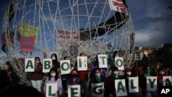 Mujeres sostienen letras que forman la frase "aborto legal ahora" durante una protesta por el derecho al aborto en Quito, el lunes 28 de septiembre de 2020.