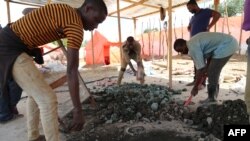 Les ouvriers artisanaux trient les minerais, sur la route entre Kolwezi et Lubumbashi, le 15 février 2018.