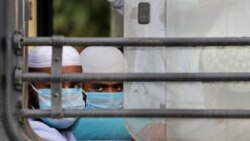 FILE - Indian Muslims wait in a bus to be taken to a coronavirus quarantine facility, in the Nizamuddin area of New Delhi, India, March 31, 2020.